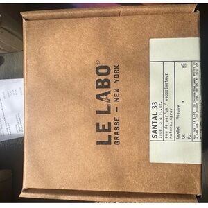 Le Labo Santal 33 Clear Glass Bottle on Gray Surface